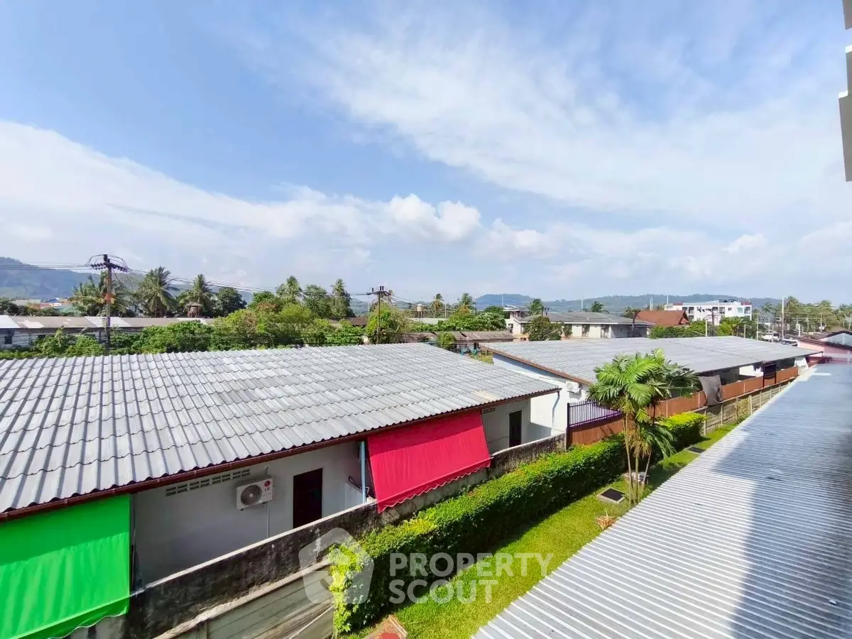 Scenic view from balcony overlooking rooftops and lush greenery
