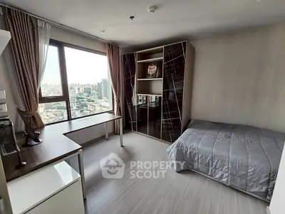 Modern bedroom with city view, sleek furniture, and large window in high-rise apartment.