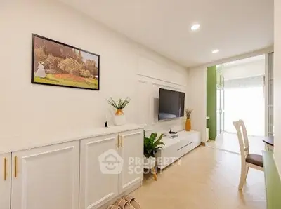 Modern living room with sleek white cabinetry and wall-mounted TV