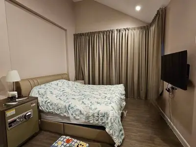 Cozy bedroom with modern decor and wall-mounted TV