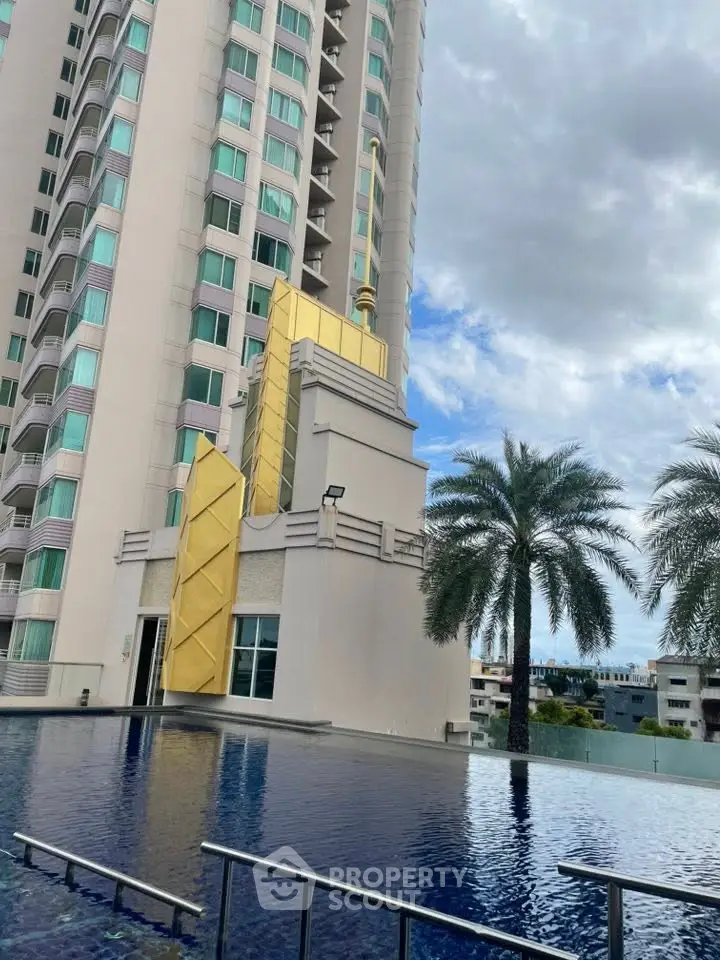Luxurious high-rise building with stunning pool and palm trees, offering a serene urban oasis.