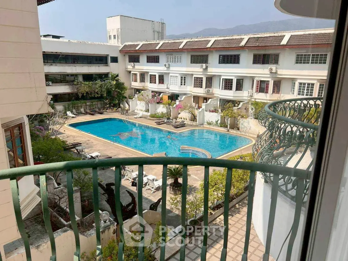 Charming residential complex with a spacious pool view from a balcony, ideal for relaxation and leisure.