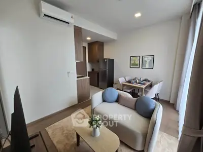 Modern living room with cozy seating and stylish decor in an open-plan apartment.