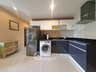 Modern kitchen with sleek cabinets, stainless steel appliances, and washing machine.