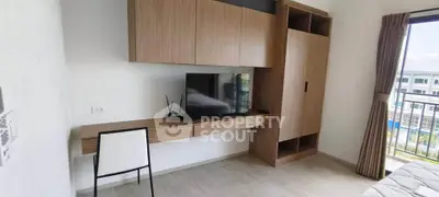 Modern bedroom with built-in wooden storage and TV, featuring a large window with city view.