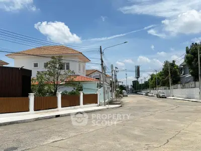 Charming suburban street view with modern houses and clear blue sky, perfect for family living.