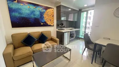 Modern living room with stylish decor and compact kitchen in open layout apartment.