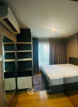 Modern bedroom with large window and built-in shelving in a stylish apartment.