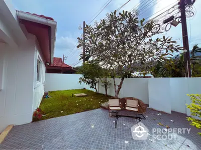 Charming backyard with tiled patio and lush greenery, perfect for relaxation and outdoor gatherings.