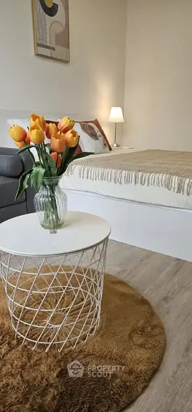 Cozy bedroom with stylish decor and vibrant tulip centerpiece.