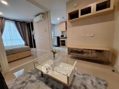 Modern apartment interior with open living room and bedroom, stylish furniture, and natural light.