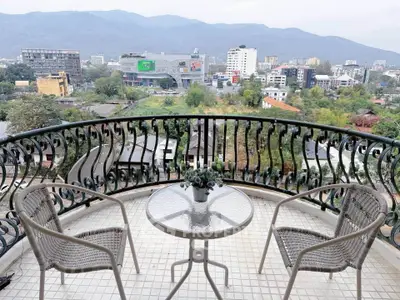 Charming balcony with cityscape view and elegant wrought iron railing, perfect for relaxation.