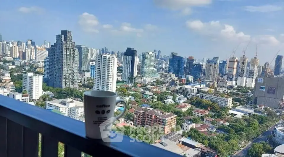 Stunning cityscape view from a high-rise balcony with a coffee mug, perfect for urban living.