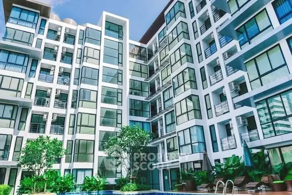 Modern apartment building with large windows and poolside view, perfect for urban living.