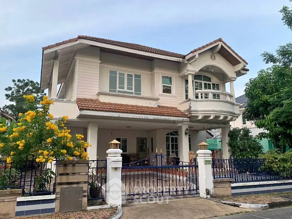 Charming two-story house with lush garden and elegant architecture.