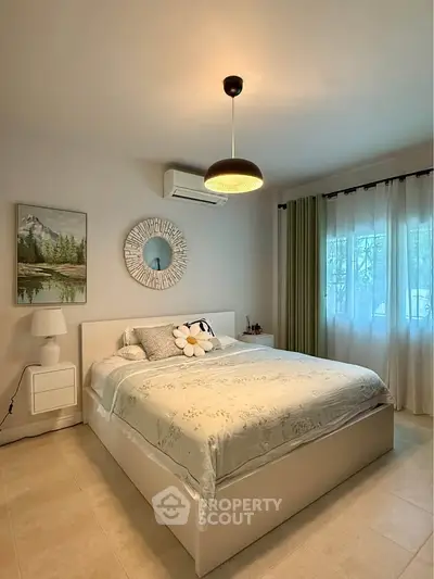 Cozy bedroom with modern decor, featuring a stylish bed, elegant lighting, and serene wall art.