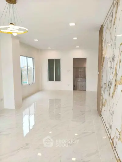 Spacious modern living room with marble accents and large windows in a luxury apartment.