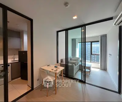 Modern apartment with open living room and kitchen, featuring floor-to-ceiling windows and sleek design.