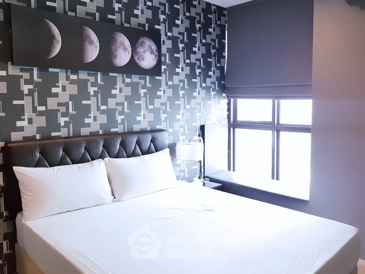 Modern bedroom with stylish wallpaper and moon phase artwork above bed