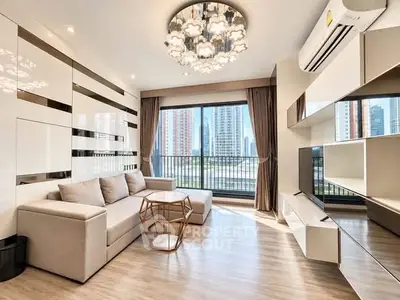 Modern living room with stylish decor and city view, featuring a cozy sofa and elegant lighting.