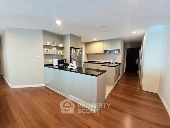 Spacious modern kitchen with sleek countertops and wooden flooring