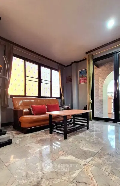 Spacious living room with marble flooring and stylish leather sofa