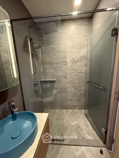 Modern bathroom with sleek glass shower and stylish blue basin