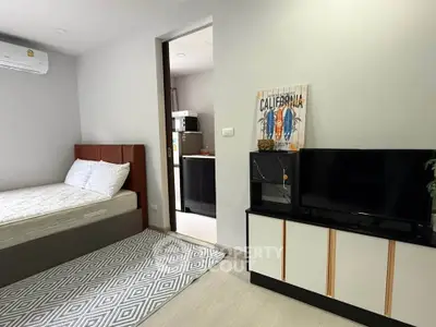 Modern bedroom with stylish decor and adjacent kitchen area in a cozy apartment.