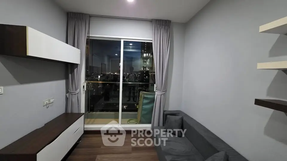Modern living room with city view from balcony, featuring sleek furniture and elegant decor.