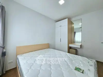 Modern bedroom with minimalist design featuring a comfortable bed and sleek wardrobe.