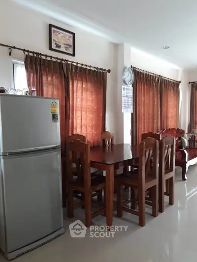 Spacious dining area with wooden furniture and natural light, perfect for family gatherings.