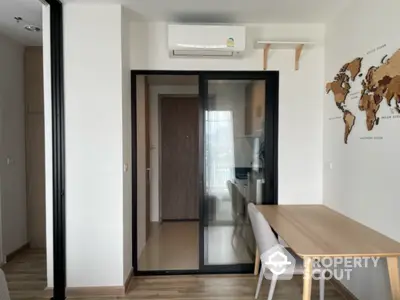 Modern apartment interior with dining area and air conditioning, featuring a world map decor.