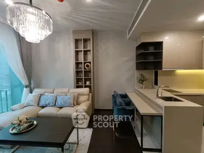 Modern living room with elegant chandelier and open kitchen layout
