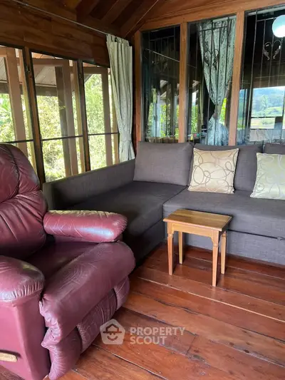 Charming living room with cozy seating and wooden accents, perfect for relaxation.
