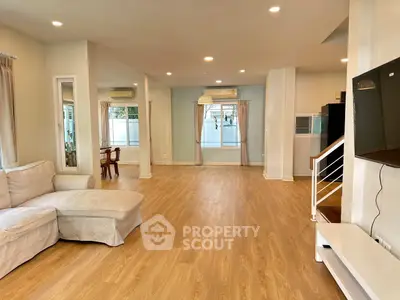 Spacious open-plan living room with modern decor and wooden flooring