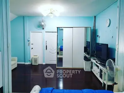 Spacious living room with modern decor and vibrant blue walls, featuring sleek furniture and a cozy ambiance.