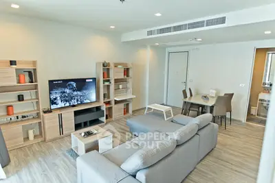 Spacious modern living room with stylish furniture and open dining area, perfect for entertaining.