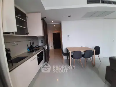 Modern open-layout kitchen and dining area with sleek cabinetry and contemporary furniture.