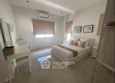 Spacious bedroom with modern decor and natural light, featuring a comfortable bed and study area.
