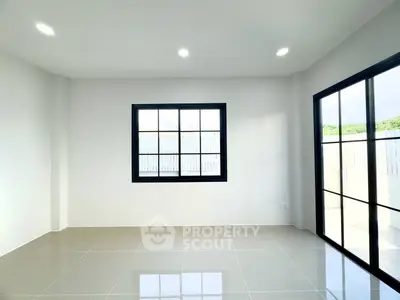 Bright and spacious room with large windows and glossy tiled floor, perfect for modern living.