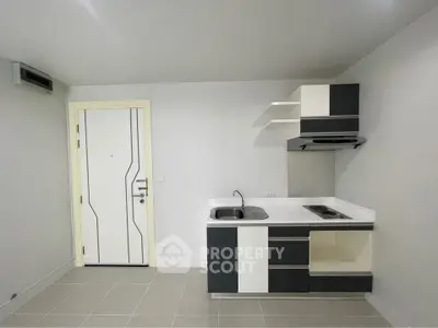 Modern minimalist kitchen with sleek cabinetry and compact design in a bright apartment.