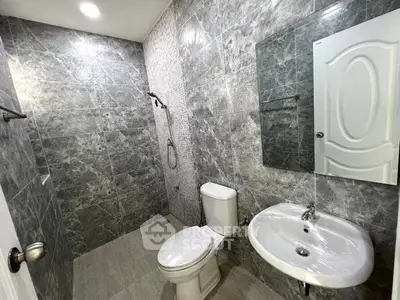 Modern bathroom with sleek gray tiles and contemporary fixtures.