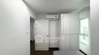 Modern bedroom with white wardrobe and city view window