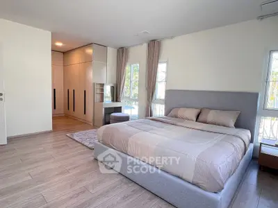 Spacious modern bedroom with elegant decor and large windows