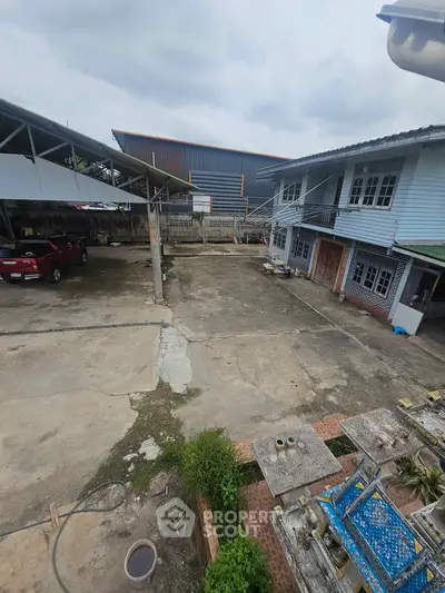 Spacious outdoor area with parking and multi-story building, ideal for residential or commercial use.