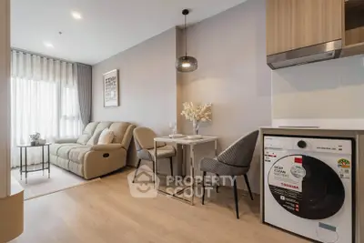 Modern living room with cozy seating and in-unit washing machine, perfect for urban living.