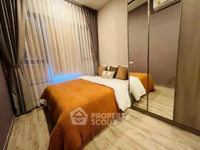 Cozy bedroom with mirrored wardrobe and elegant curtains, perfect for relaxation.