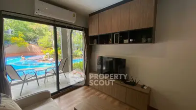 Chic living room with poolside view, modern furniture, and large sliding glass doors.