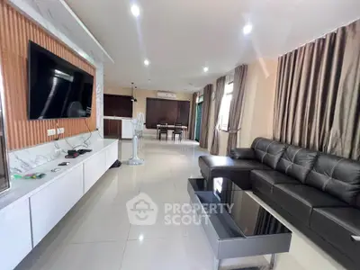 Spacious modern living room with sleek furniture and large TV, perfect for entertainment.