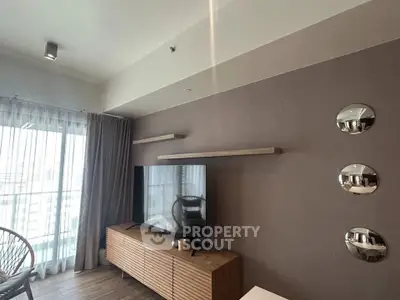 Modern living room with sleek TV unit and large window offering natural light